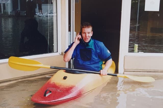 Mike Rhodes kayaking through flooded office