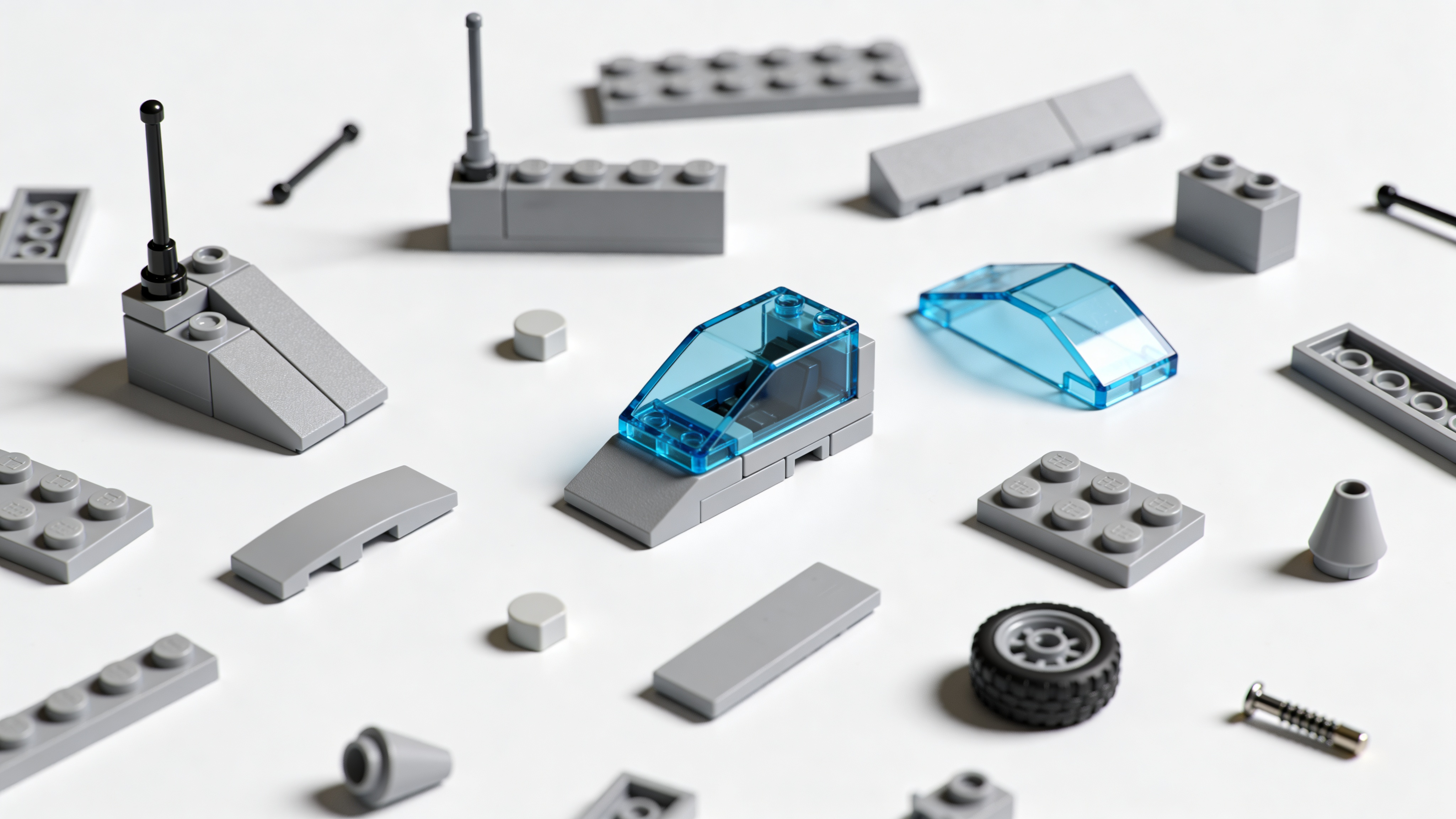 Loose Lego space pieces scattered on a white surface - bricks, slopes, antenna rods, wheels